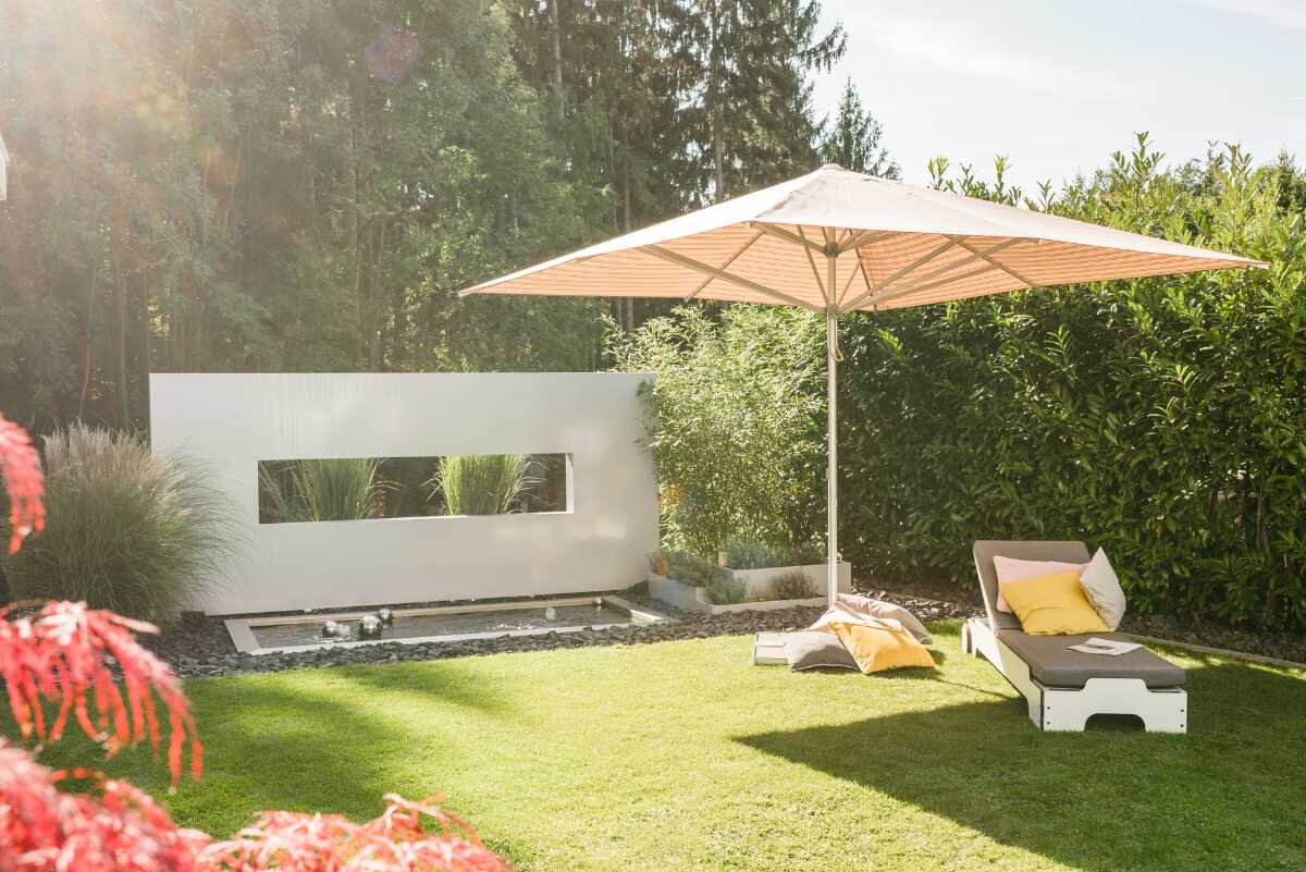 Entspannungsbereich im Garten mit Liegestuhl und Sonnenschirm